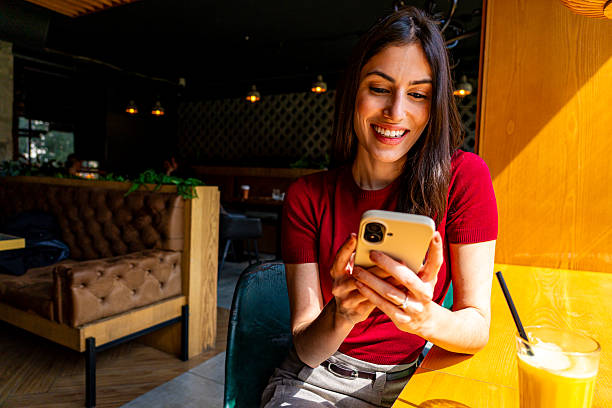 istock Happy businesswoman using mobile phone in restaurant enjoying break 2209165909