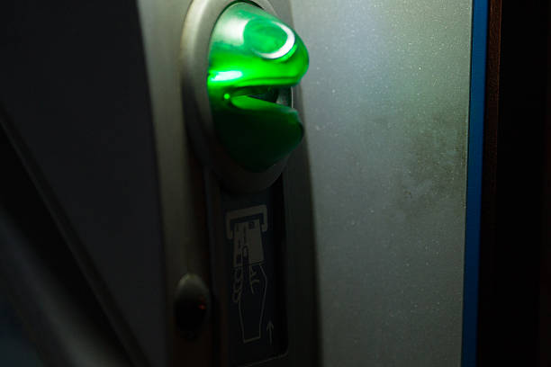Detailed closeup of an ATM machine, close-up of the card slot along with shining green status indicator lights.