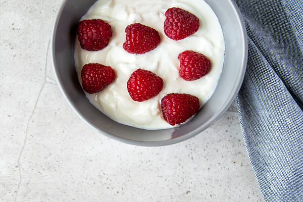 istock Gray bowl and natural yogurt with berries on the stone marble table. 2209171061