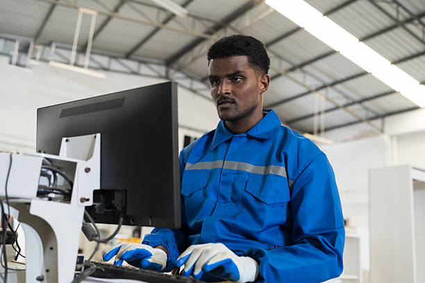 istock Plywood processing plant. Furniture manufacturing. Operator use desktop computer control CNC cutting machine at industry factory 2209173335
