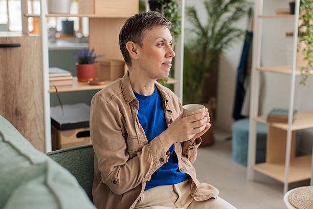istock Woman relaxing and drinking coffee at home 2209173444
