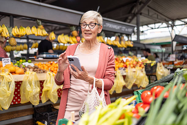 istock Senior woman using smartphone at market 2209173461