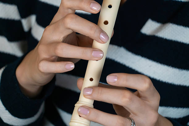istock Female musician skillfully playing a recorder flute, demonstrating precise finger placement and creating beautiful music with her instrument 2209173993