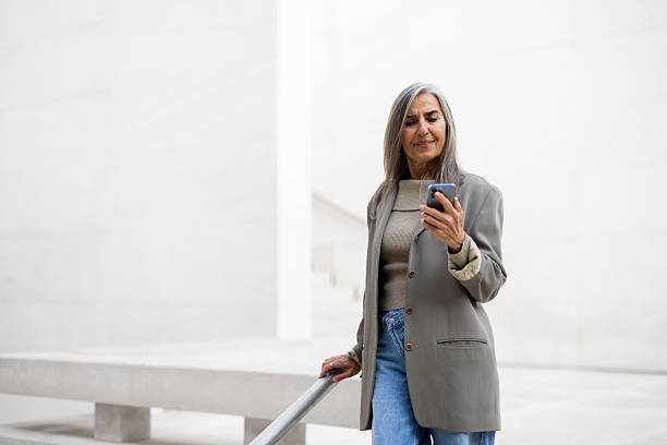 istock Beautiful woman in a walk using smartphone on the way 2209175174