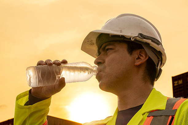 istock logistics workers man drinking water on site area operations at a busy shipping container yard at sunset. successful coordination in freight, transportation, and supply chain operations 2209175254