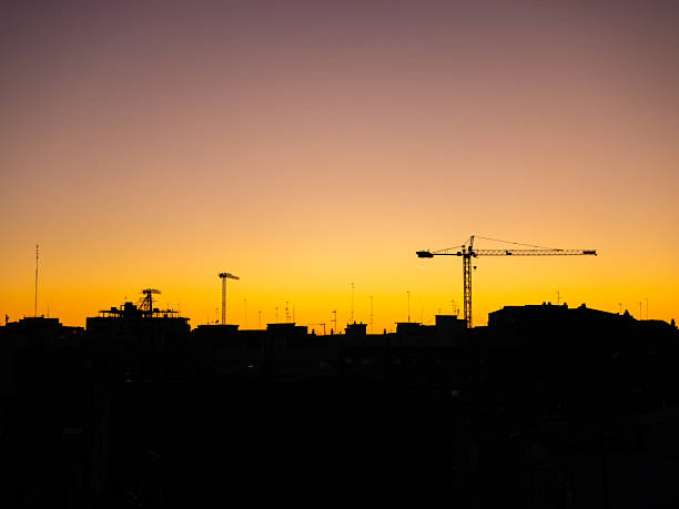 istock Construction cranes silhouette at golden sunset 2209175948