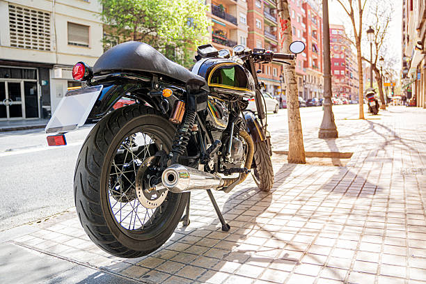 istock Retro motorcycle parked on sunny city sidewalk 2209175968