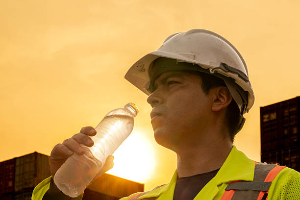 istock logistics workers man drinking water on site area operations at a busy shipping container yard at sunset. successful coordination in freight, transportation, and supply chain operations 2209176877