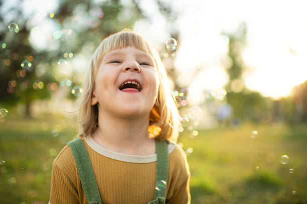 Little girl playing in a park with soap bubbles