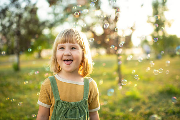 istock Little girl playing in a park with soap bubbles 2209177399