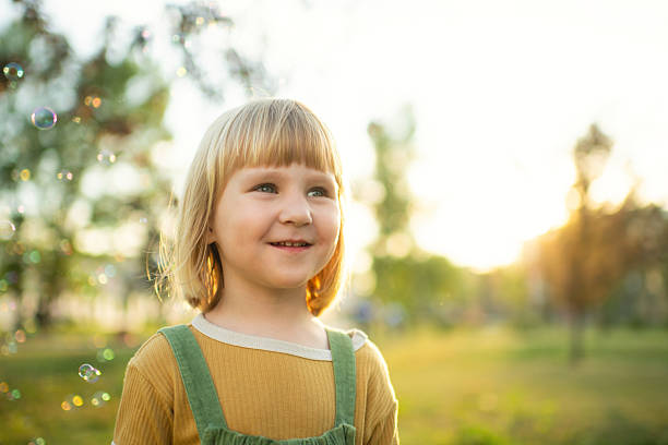 istock Little girl playing in a park with soap bubbles 2209177416