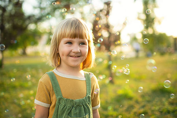 istock Little girl playing in a park with soap bubbles 2209177428