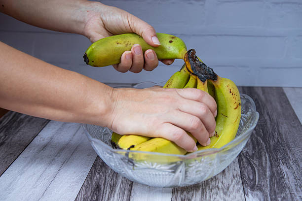 istock hands pluck a fresh banana from the bowl 2209178135