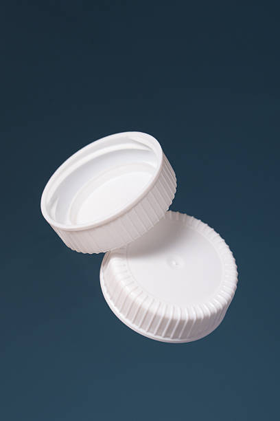 istock Two white plastic bottle caps on a blue background. Front and back of the cap. 2209179260