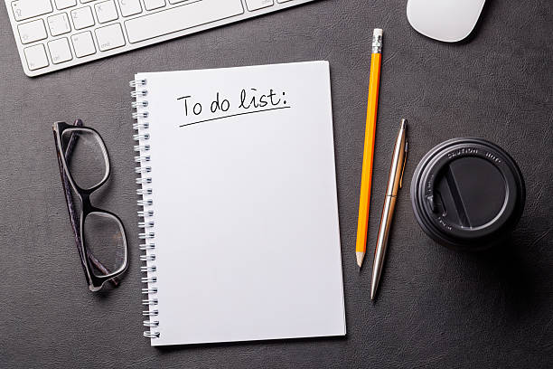 istock Organized work desk setup with PC, office supplies, coffee, and a notepad for writing a to-do list 2209179638