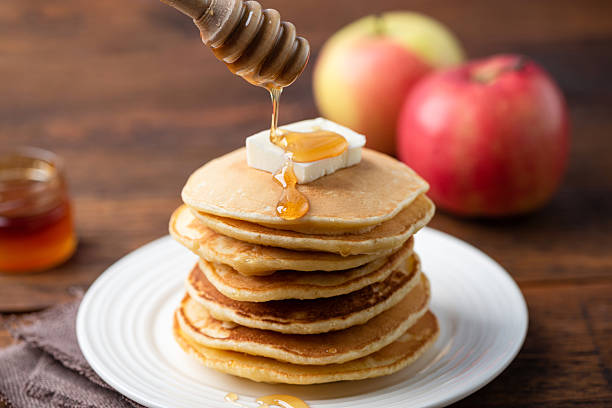 istock Pancakes stack with butter and pouring honey 2209179768