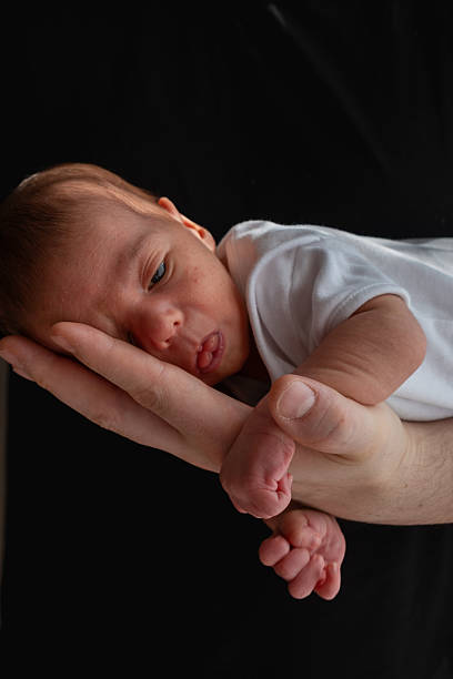 istock Newborn Baby Cradled in Hand 2209181054