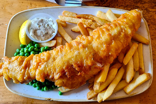 istock Classic Fish and Chips with Peas and Tartar Sauce on Rustic Plate 2209181186