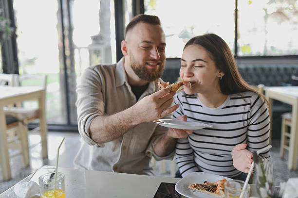 istock Female Enjoying Pizza Slice With Closed Eyes While Boyfriend is Feeding Her 2209181235