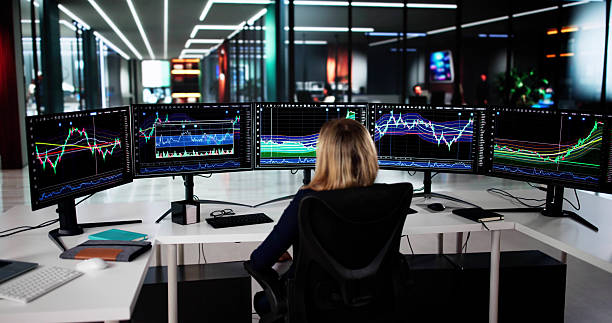 istock Young Female Stock Market Analyst Reviews Multiple Computer 2209182601