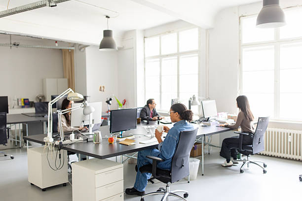 istock Group of business professionals working in an open plan coworking office space 2209182623