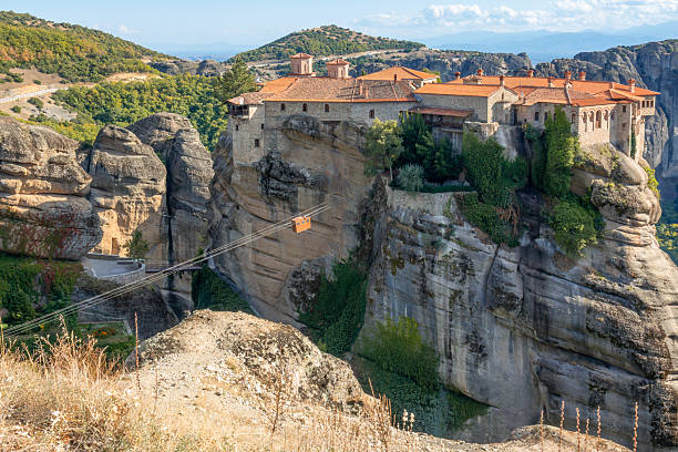 Northern Greece. Sunny summer day in Meteora. Monastery on the top of the cliff and the cable car for monks