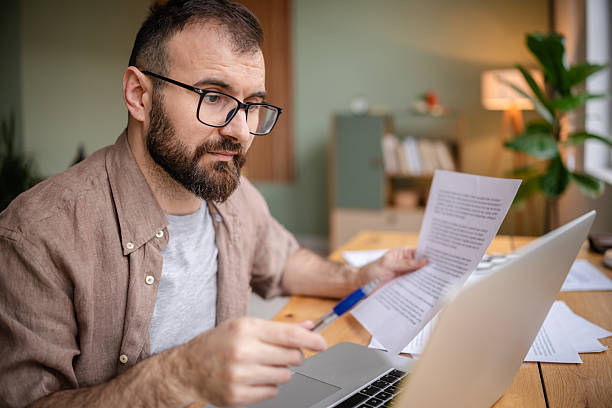 istock Young man focused on freelance work at home, collaborating with technology in a cozy apartment setting 2209187307