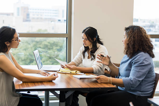 istock Three Diverse Women in Business Casual Discussing Documents 2209187577