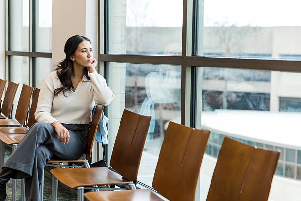 istock Thoughtful Woman Sitting by Window in Office Building 2209187671