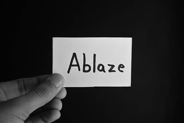istock Hand holding a paper card with the word ABLAZE 2209190848