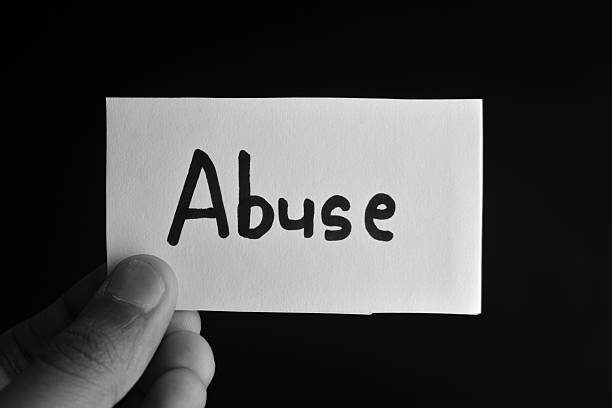 istock Hand holding a paper card with the word ABUSE 2209191040
