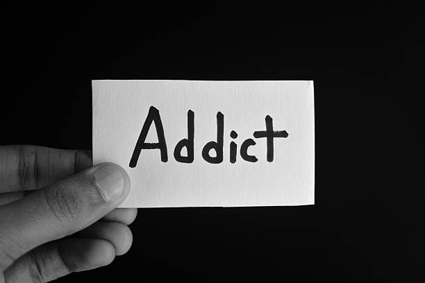 istock Hand holding a paper card with the word ADDICT 2209191842