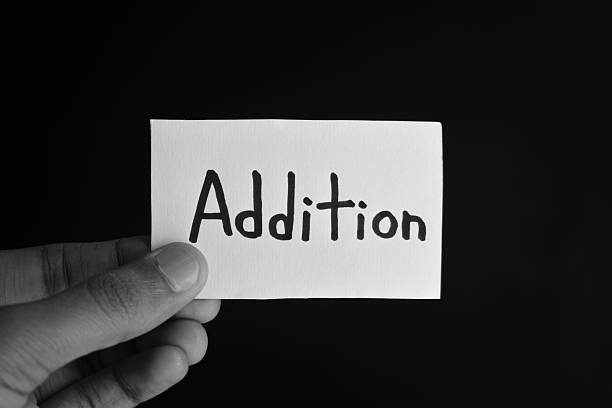 istock Hand holding a paper card with the word ADDITION 2209191973