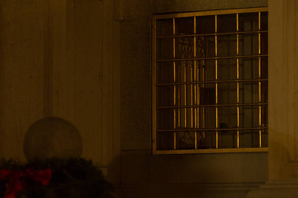A beautifully grilled window adorning a building facade stands out at night, surrounded by various architectural elements and features