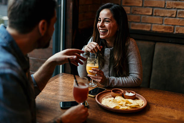 istock Young couple enjoying drinks and snacks at a restaurant 2209194508