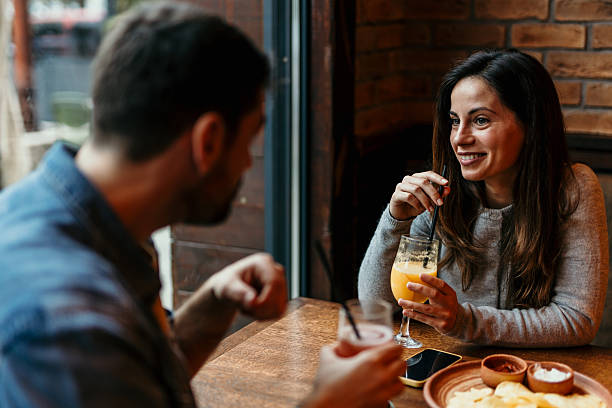 istock Couple enjoying drinks and conversation at a restaurant 2209194533