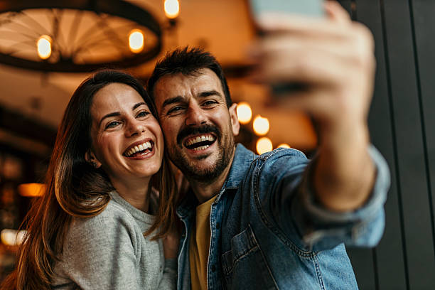 istock Happy couple taking a selfie in a restaurant 2209194553