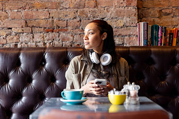 Distracted woman at a cafe using her cell phone and looking away - lifestyle concepts