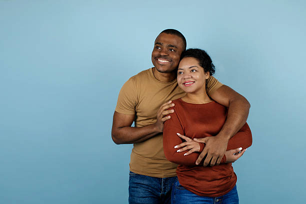 istock Young black couple embracing affectionately and looking aside at copy space 2209194760