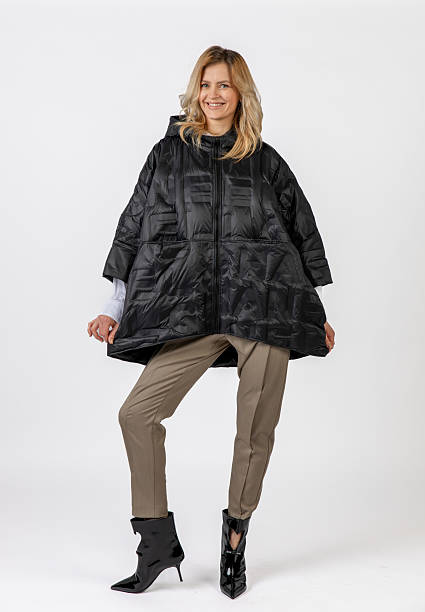istock Smiling Caucasian Woman Modeling Black Coat and Stylish Attire in Studio Setting 2209195528