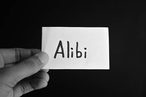 istock Hand holding a paper card with the word ALIBI 2209195628