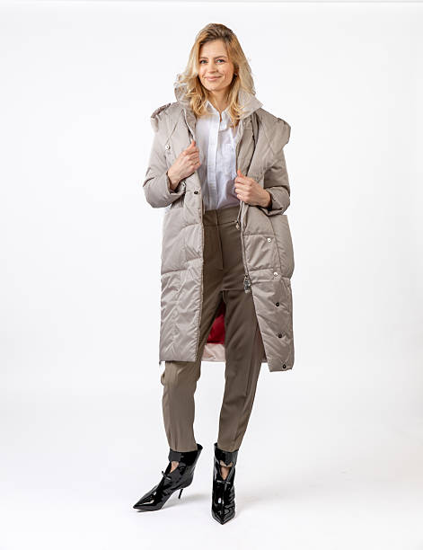 istock Stylish Woman Modeling a Winter Coat and Formal Outfit in a Studio Setting 2209195939