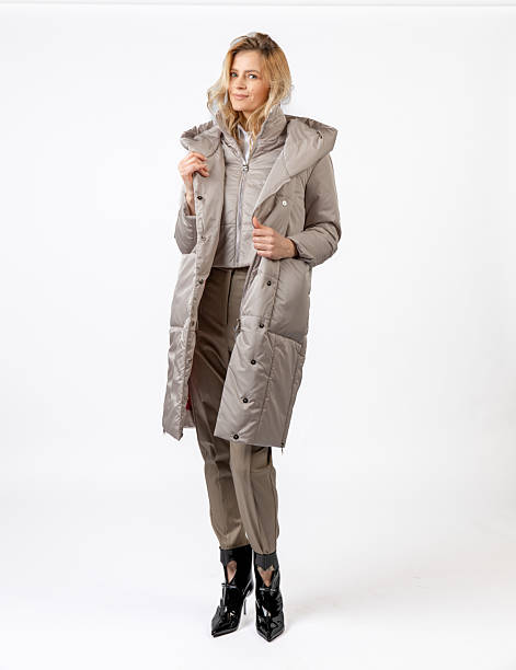 istock Stylish Woman Modeling a Winter Coat and Formal Outfit in a Studio Setting 2209196149