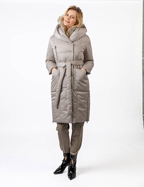 istock Stylish Woman Modeling a Winter Coat and Formal Outfit in a Studio Setting 2209196341