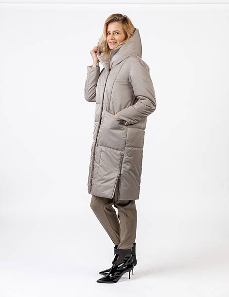 istock Stylish Woman Modeling a Winter Coat and Formal Outfit in a Studio Setting 2209196410