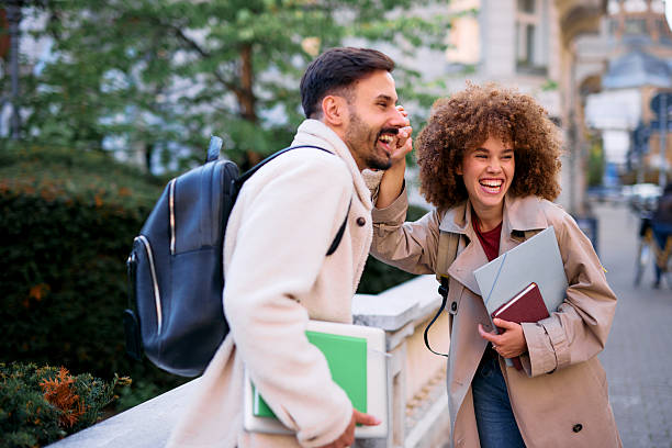 istock Two happy students laughing and whispering secrets on campus 2209196562