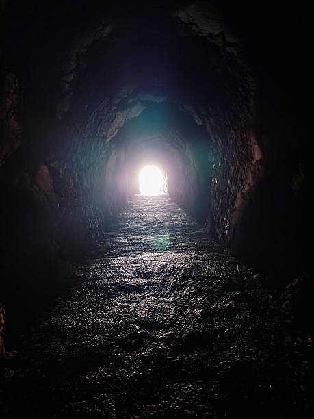 istock Dark tunnel with light at the end. Metaphor for hope, overcoming obstacles, or finding a new path. Evokes mystery, adventure, and the journey from darkness to light. 2209196706
