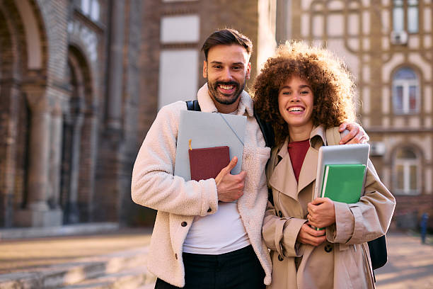 istock Two happy students embracing outside university building 2209196747