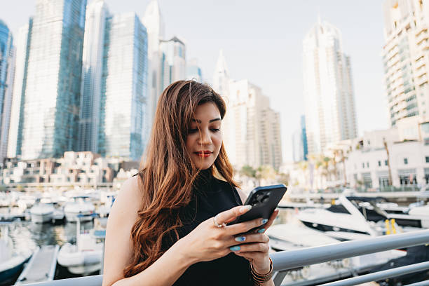 istock Young businesswoman using smartphone in Dubai Marina 2209196892