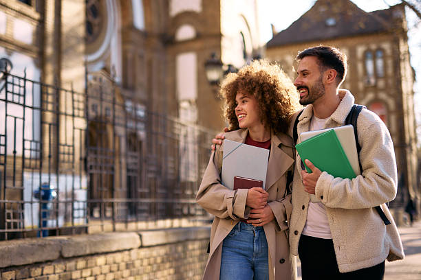 istock Two happy students walking and talking outside of university 2209196895